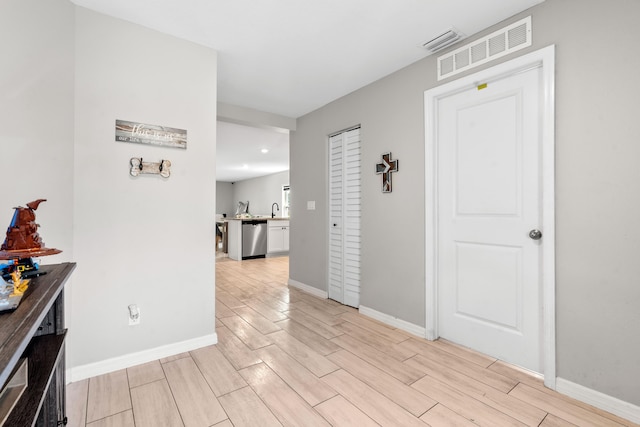 885 SW Squirrel Ave, Port Saint Lucie, FL 34953 - hallway featuring light wood-type flooring, baseboards, and a sink
