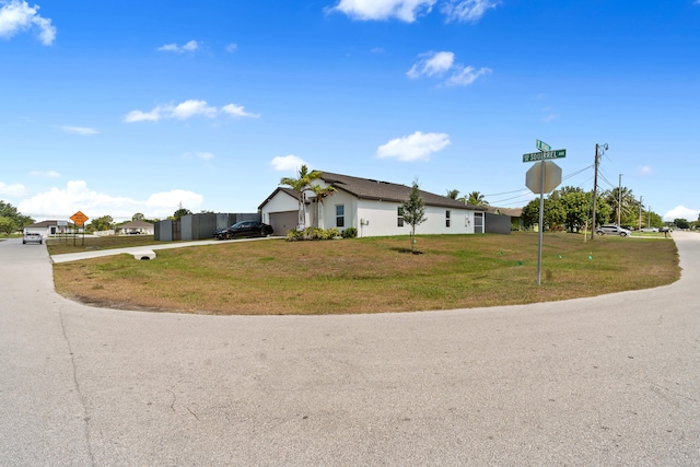 885 SW Squirrel Ave, Port Saint Lucie, FL 34953 - view of front of home with driveway, an attached garage, and a front yard