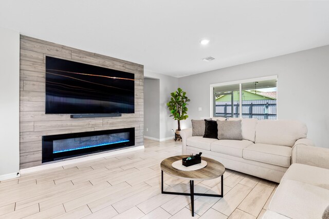 885 SW Squirrel Ave, Port Saint Lucie, FL 34953 - living room featuring baseboards, a fireplace, wood finished floors, and recessed lighting
