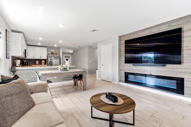 885 SW Squirrel Ave, Port Saint Lucie, FL 34953 - living room with baseboards, light wood-type flooring, recessed lighting, and a fireplace