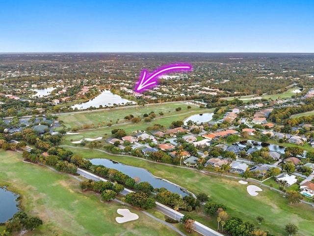 drone / aerial view with a water view and golf course view