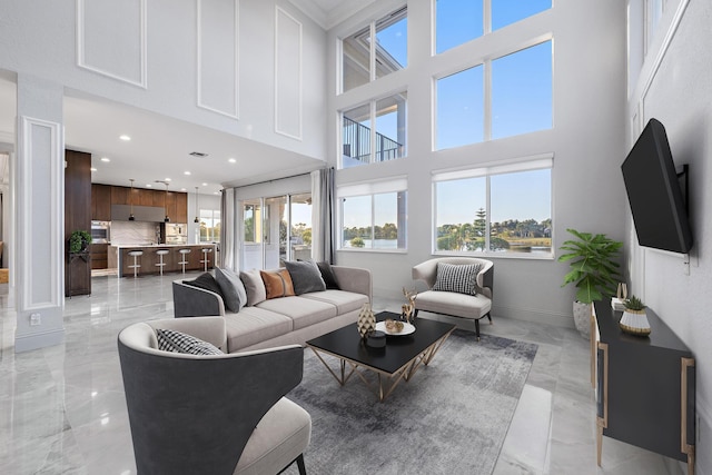 living room featuring marble finish floor, baseboards, a towering ceiling, and recessed lighting