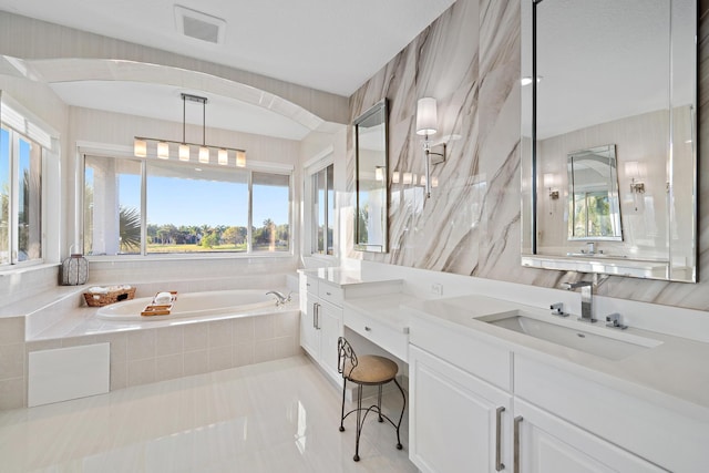 bathroom with a bath, visible vents, and vanity