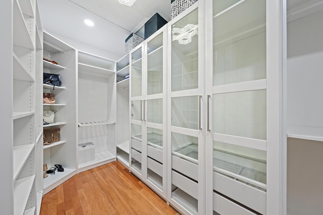 walk in closet with light wood-style flooring