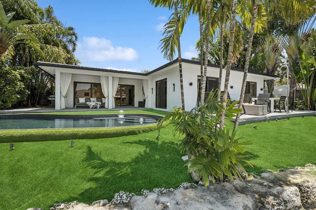 2409 NE 18th Ave, Wilton Manors, FL 33305 - back of property featuring a patio, an outdoor pool, a lawn, outdoor lounge area, and stucco siding