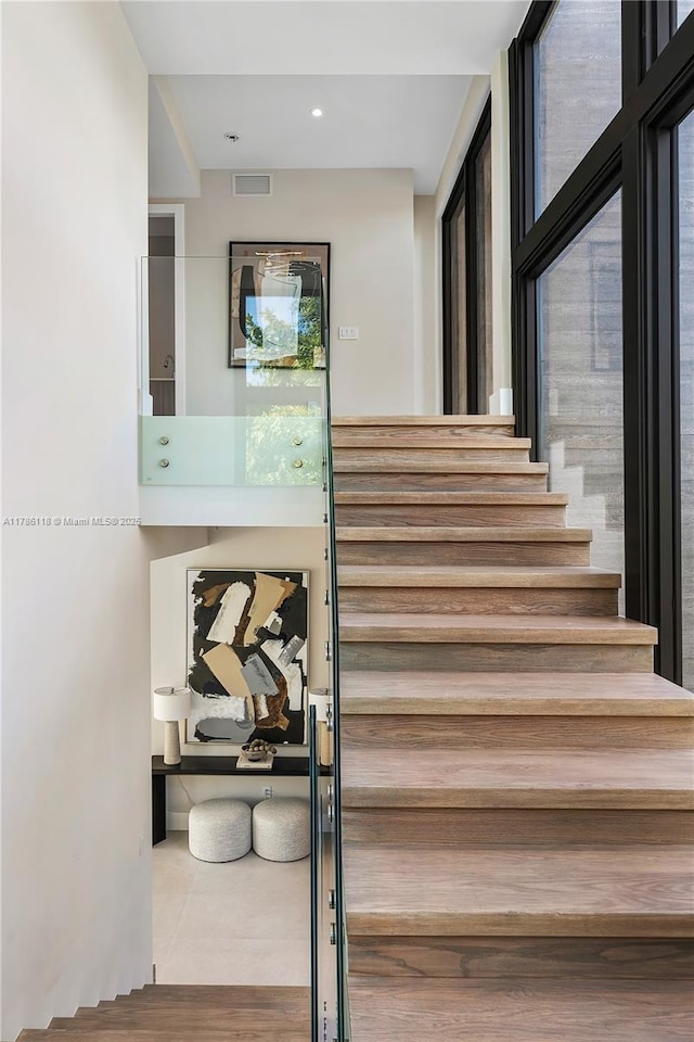 stairs featuring wood finished floors and visible vents