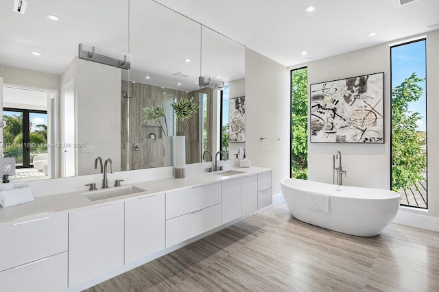 full bathroom featuring a sink, recessed lighting, double vanity, and a stall shower