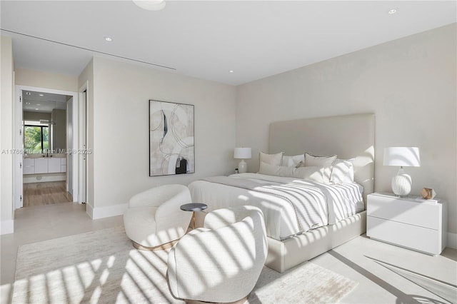 bedroom featuring baseboards, ensuite bathroom, and recessed lighting
