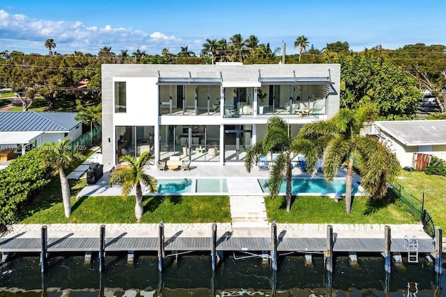 back of house with fence, a lawn, a patio, a balcony, and an outdoor pool