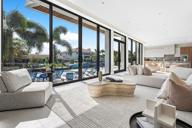 living room with light tile patterned floors and a wall of windows