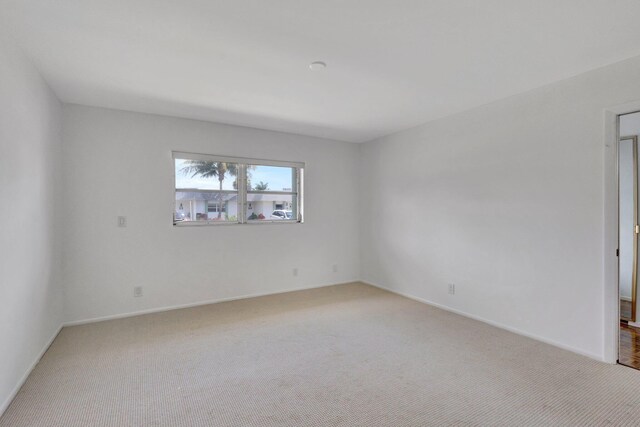 carpeted empty room with baseboards