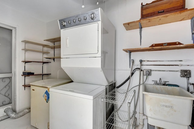 laundry area with stacked washer and dryer, laundry area, and a sink