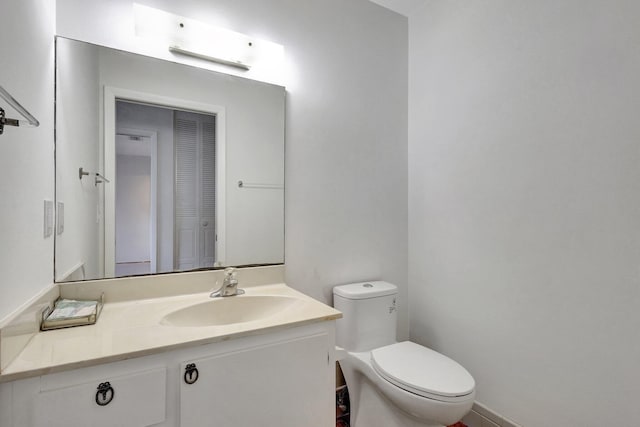 bathroom with vanity, toilet, and baseboards
