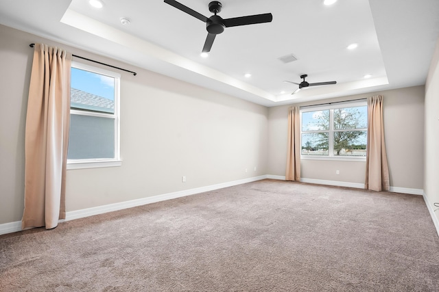 empty room featuring carpet, a ceiling fan, a raised ceiling, and recessed lighting