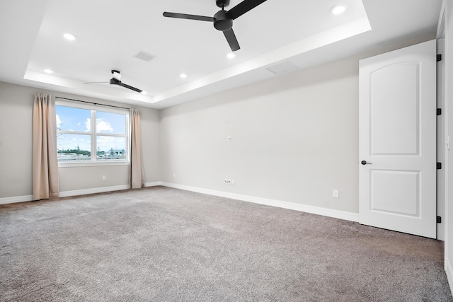 spare room featuring a tray ceiling, carpet, a ceiling fan, and recessed lighting