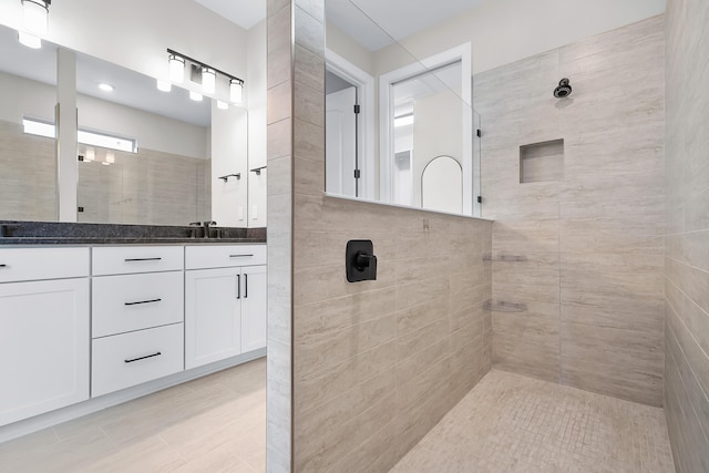 full bathroom featuring a walk in shower and vanity