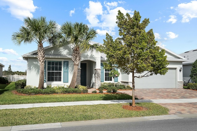 view of front of house with a garage, stucco siding, a front lawn, and decorative driveway