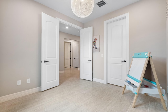living area featuring baseboards and visible vents