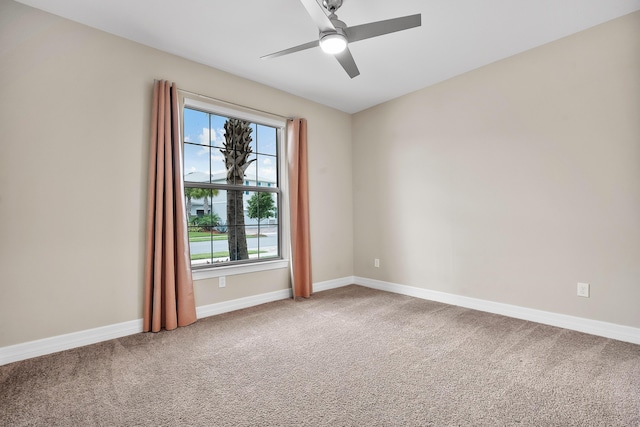 empty room with baseboards, a wealth of natural light, a ceiling fan, and carpet