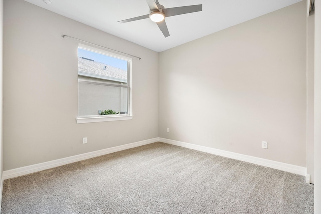 carpeted empty room featuring ceiling fan and baseboards