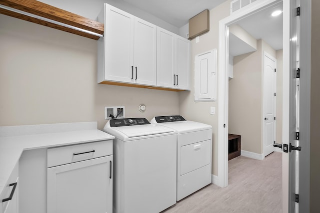 washroom with baseboards, visible vents, electric panel, separate washer and dryer, and cabinet space