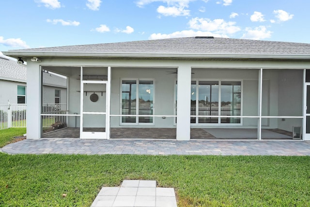 back of property with a sunroom, fence, and a lawn
