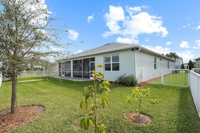 back of house with a yard, a sunroom, and a fenced backyard