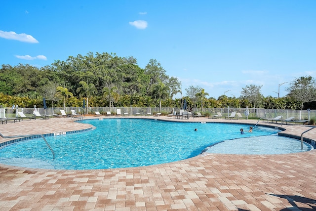 community pool featuring a patio area and fence