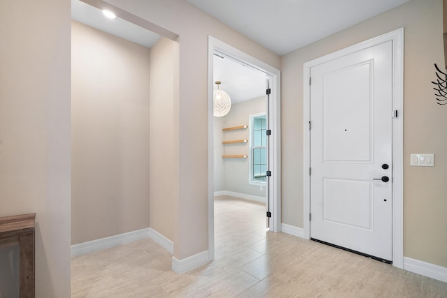 foyer entrance with light wood-type flooring and baseboards