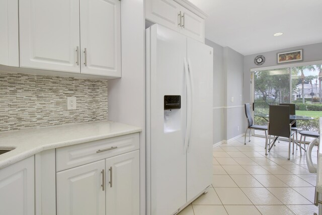 6907 Fountains Cir, Lake Worth, FL 33467 - kitchen featuring white fridge with ice dispenser, backsplash, light tile patterned flooring, white cabinets, and light countertops