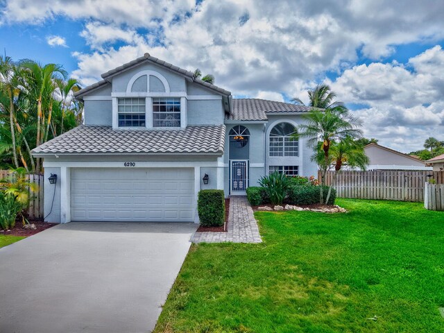 6290 Windchime Pl, Boynton Beach, FL 33472 - view of front of house with fence, a front yard, stucco siding, concrete driveway, and an attached garage