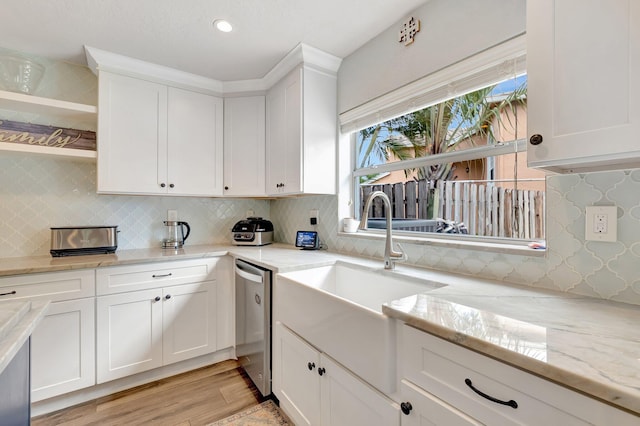 6290 Windchime Pl, Boynton Beach, FL 33472 - kitchen with backsplash, stainless steel dishwasher, light wood-type flooring, a sink, and white cabinetry