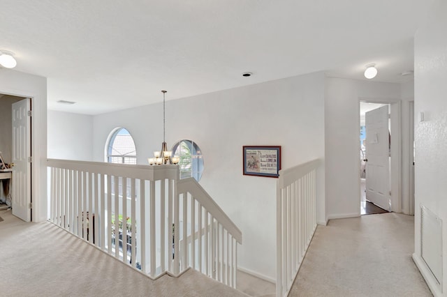 6290 Windchime Pl, Boynton Beach, FL 33472 - corridor featuring an upstairs landing, carpet flooring, visible vents, and a notable chandelier