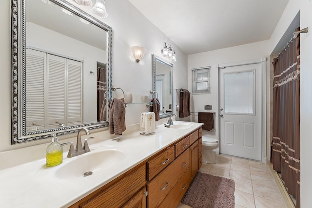 full bathroom featuring double vanity, toilet, a sink, and a closet