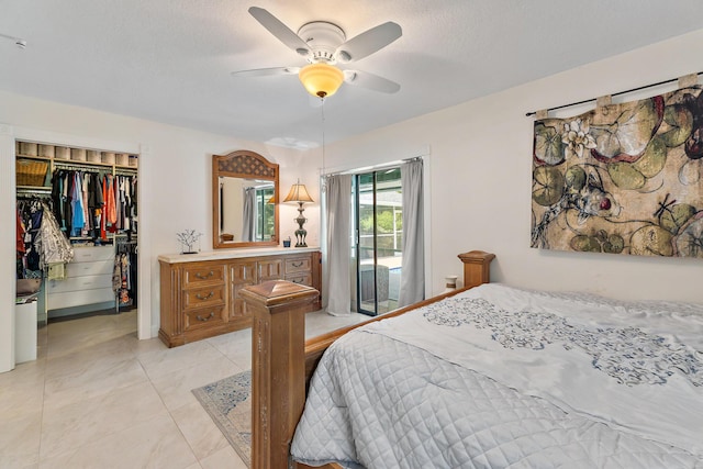 bedroom featuring a closet, ceiling fan, light tile patterned floors, and a spacious closet