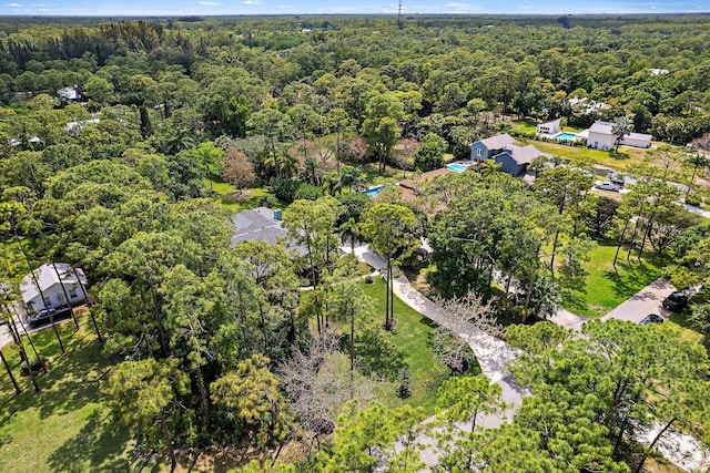 birds eye view of property featuring a view of trees