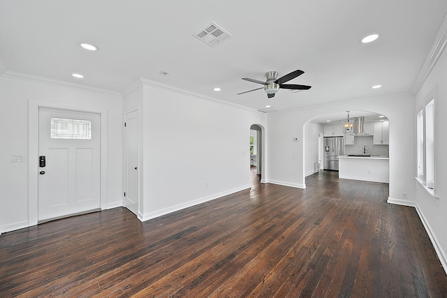 725 N Ocean Breeze, Lake Worth Beach, FL 33460 - unfurnished living room with arched walkways, a ceiling fan, recessed lighting, dark wood-type flooring, and crown molding