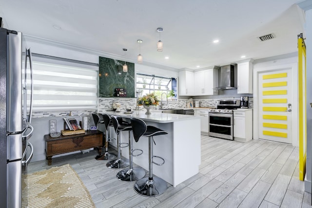 1050 Singer Dr, Singer Island, FL 33404 - kitchen with decorative backsplash, stainless steel appliances, wall chimney exhaust hood, a peninsula, and visible vents