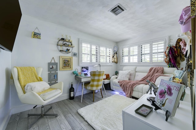 1050 Singer Dr, Singer Island, FL 33404 - living area featuring baseboards, wood finished floors, visible vents, and a textured ceiling