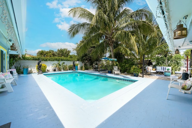 1050 Singer Dr, Singer Island, FL 33404 - view of swimming pool with outdoor lounge area, a patio area, a fenced in pool, and a fenced backyard