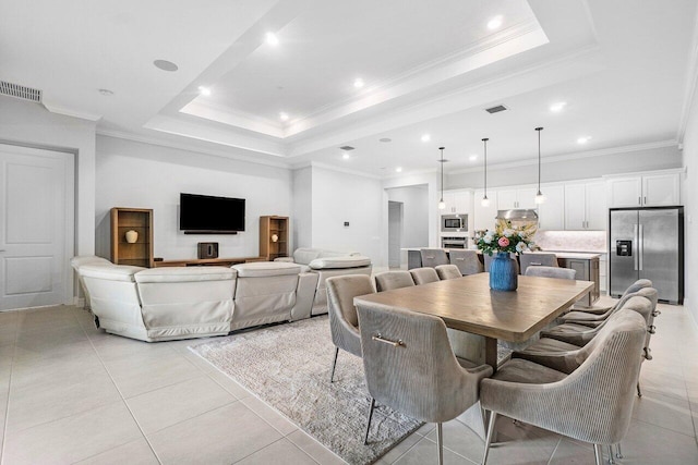 dining room featuring a raised ceiling, ornamental molding, light tile patterned flooring, and visible vents