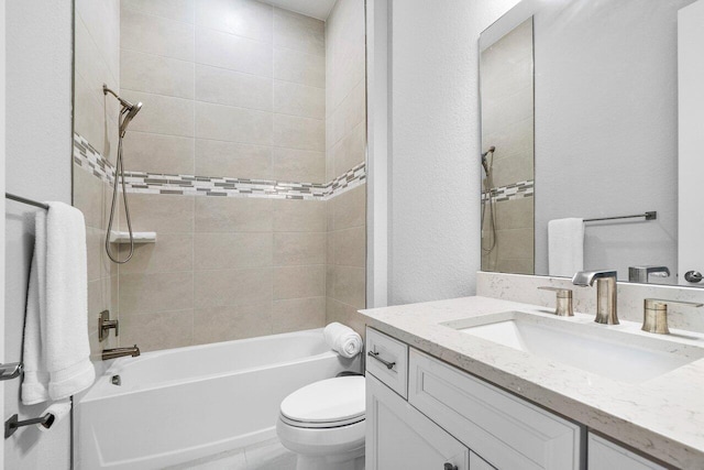 bathroom with shower / bath combination, vanity, a textured wall, and toilet