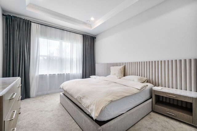 bedroom with a raised ceiling, ornamental molding, and light colored carpet