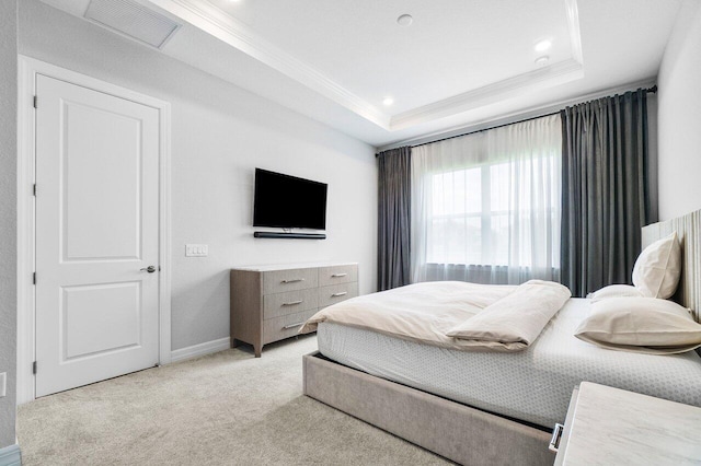 bedroom with light colored carpet, a raised ceiling, baseboards, visible vents, and ornamental molding