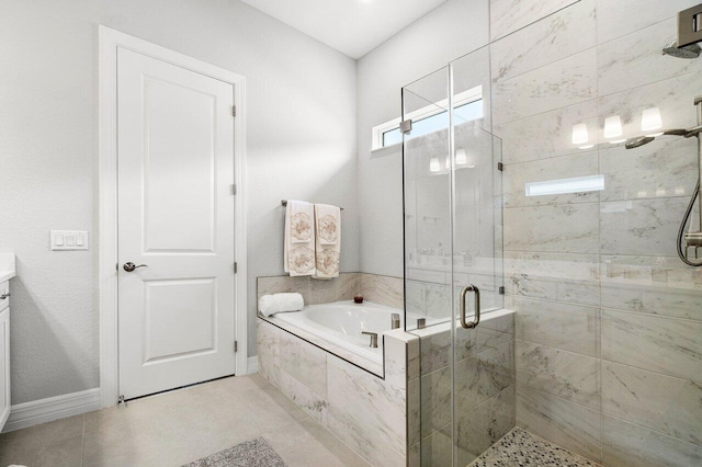 bathroom with vanity, baseboards, a stall shower, and a garden tub