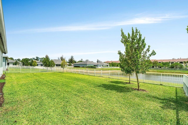 view of yard featuring a fenced backyard and a water view