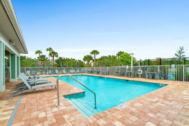 pool with a patio area and fence