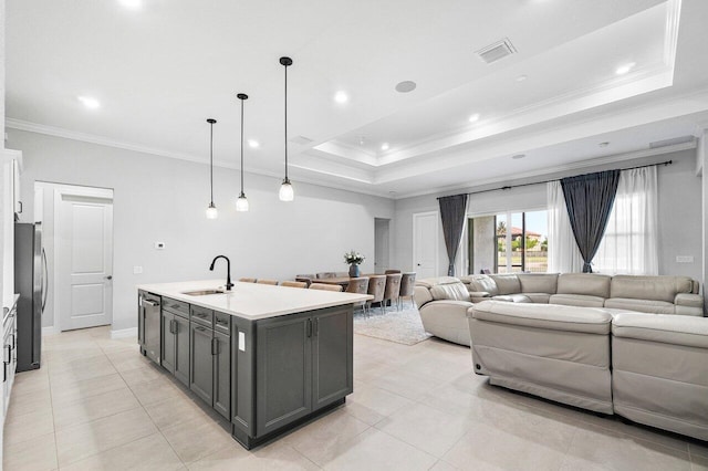 kitchen featuring visible vents, crown molding, open floor plan, a sink, and appliances with stainless steel finishes