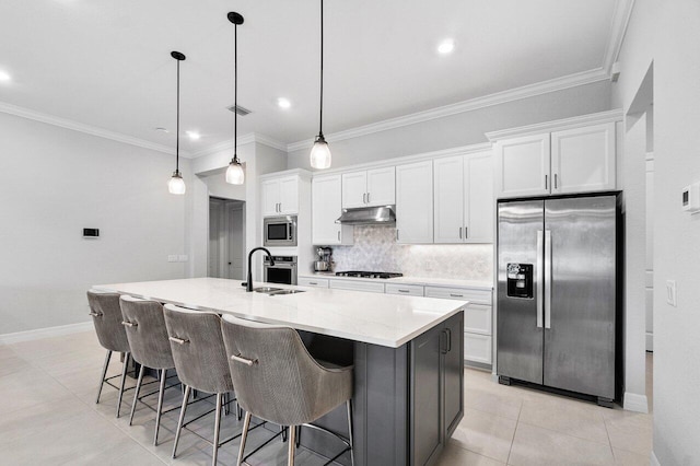 kitchen featuring appliances with stainless steel finishes, a sink, white cabinetry, tasteful backsplash, and under cabinet range hood