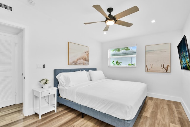 bedroom featuring ceiling fan, visible vents, wood finished floors, baseboards, and recessed lighting